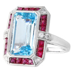 DIAMOND AND RUBY SET WITH A 14X8MM SKY BLUE TOPAZ CENTER ON WHITE GOLD RING