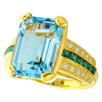 DIAMOND AND TSAVORITE SET WITH A 14X10 MM SKY BLUE TOPAZ CENTER ON YELLOW GOLD RING