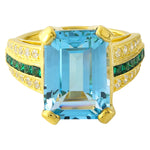 DIAMOND AND TSAVORITE SET WITH A 14X10 MM SKY BLUE TOPAZ CENTER ON YELLOW GOLD RING